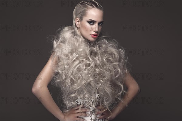 Beautiful girl in art dress with avant-garde hairstyles. Beauty the face. Photos shot in the studio