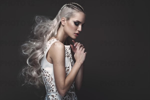 Beautiful girl in art dress with avant-garde hairstyles. Beauty the face. Photos shot in the studio