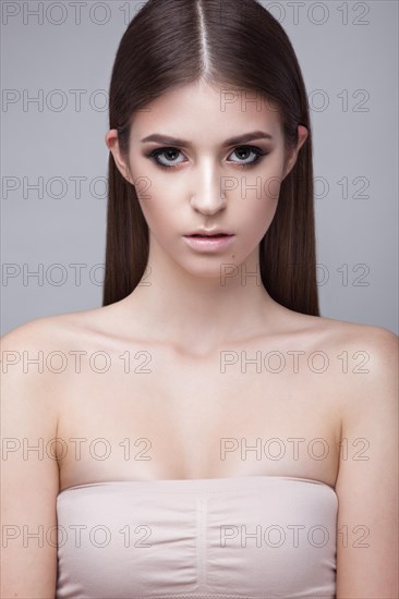Beautiful young girl with a light natural make-up. Beauty face. Picture taken in the studio