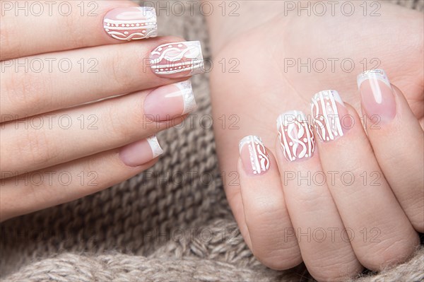 Snow White manicure on female hands. Winter nail design. Picture taken in the studio on a background of wool