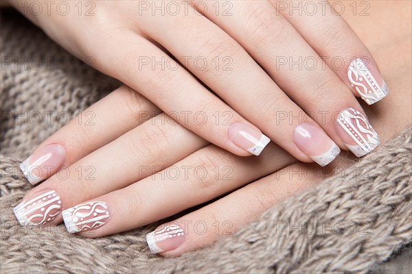 Snow White manicure on female hands. Winter nail design. Picture taken in the studio on a background of wool