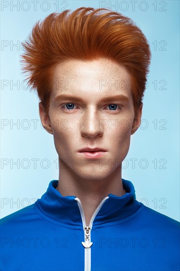 Young man with red hair and creative make up and hair. Photo taken in the studio