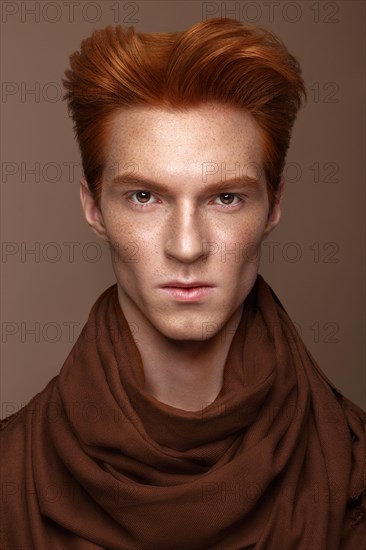 Young man with red hair and creative make up and hair. Photo taken in the studio