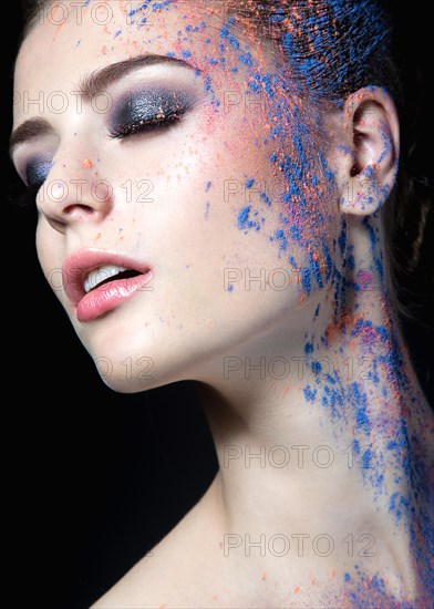 Portrait of a beautiful Girl with red paint on her face. Photo shot in the Studio on a black background