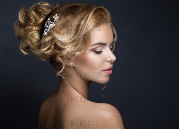 Portrait of a beautiful blond woman in the image of the bride. Picture taken in the studio on a black background. Beauty face and Hairstyle