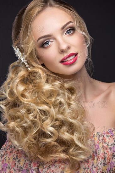 Portrait of a beautiful blond girl in image of the bride with purple flowers on her head. Beauty face. Photo shot in the Studio on a grey background