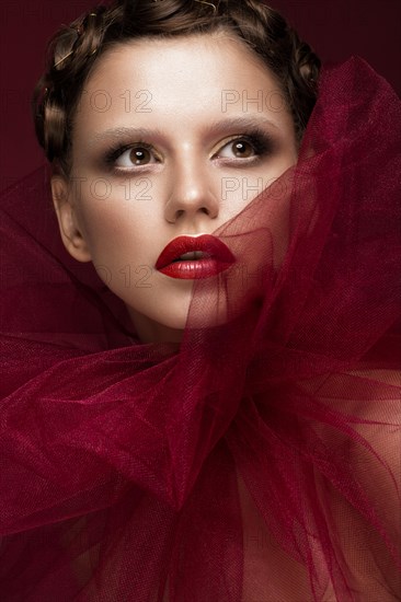 Beautiful girl with art creative make-up in the image of a red bride for Halloween. Beauty face. Photo taken in studio