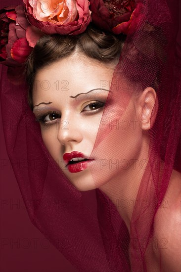 Beautiful girl with art creative make-up in the image of a red bride for Halloween. Beauty face. Photo taken in studio
