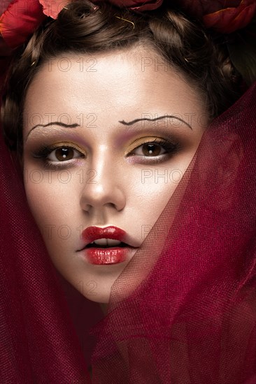 Beautiful girl with art creative make-up in the image of a red bride for Halloween. Beauty face. Photo taken in studio