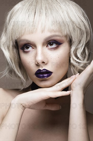 Beautiful woman with art makeup and a fashionable hair. The beauty of the face. Portrait shot in studio