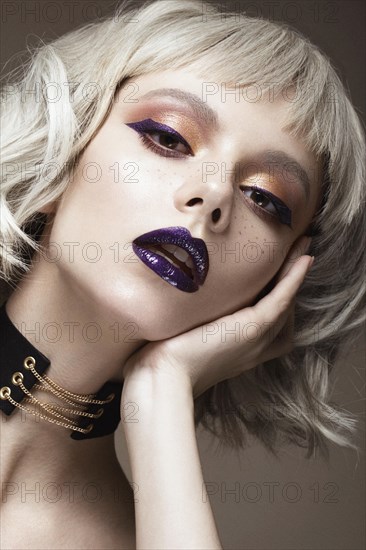 Beautiful woman with art makeup and a fashionable hair. The beauty of the face. Portrait shot in studio