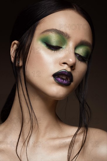 Beautiful girl with spring green makeup and vampire lips. beauty face. Photos shot in studio