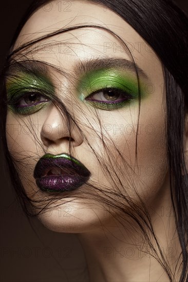 Beautiful girl with spring green makeup and vampire lips. beauty face. Photos shot in studio