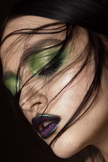 Beautiful girl with spring green makeup and vampire lips. beauty face. Photos shot in studio