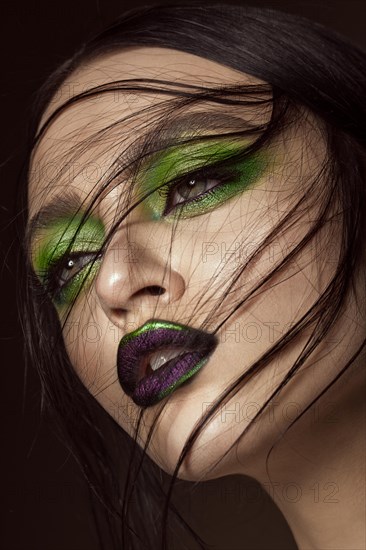 Beautiful girl with spring green makeup and vampire lips. beauty face. Photos shot in studio