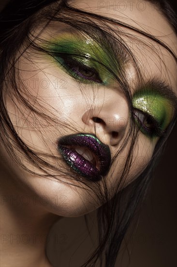 Beautiful girl with spring green makeup and vampire lips. beauty face. Photos shot in studio