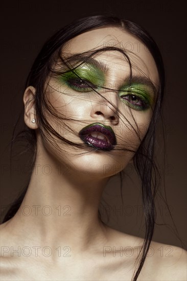 Beautiful girl with spring green makeup and vampire lips. beauty face. Photos shot in studio