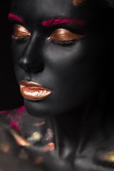 Fashion portrait of a dark-skinned girl with color make-up.Beauty face. Picture taken in the studio on a black background