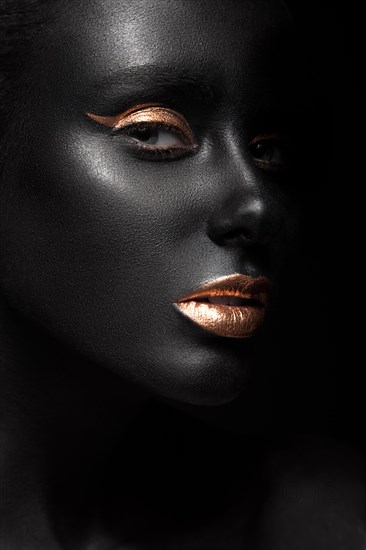 Fashion portrait of a dark-skinned girl with color make-up.Beauty face. Picture taken in the studio on a black background