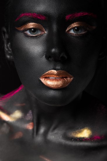 Fashion portrait of a dark-skinned girl with color make-up.Beauty face. Picture taken in the studio on a black background