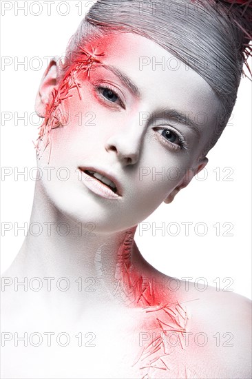 Art fashion girl with white skin and red paint on the face. Creative art beauty. Picture taken in the studio on a black background