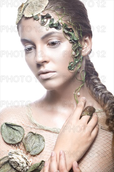 Beautiful fashionable girl in image of sea fairies with shells and algae on the face. Art beauty face. Picture taken in the studio