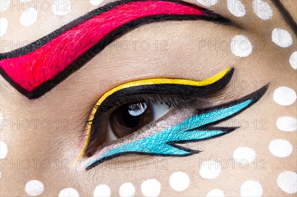 Photo of young woman with professional comic pop art make-up. Creative beauty style. Photos shot in studio. Close up