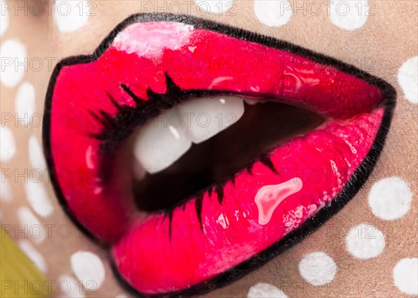 Photo of young woman with professional comic pop art make-up. Creative beauty style. Photos shot in studio. Close up lips