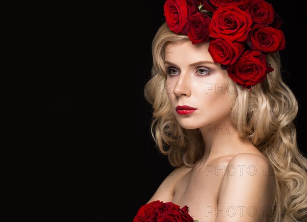 Beautiful blond girl in a dress and hat with roses