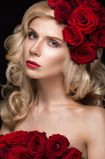 Beautiful blond girl in a dress and hat with roses