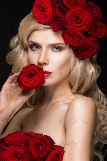 Beautiful blond girl in a dress and hat with roses