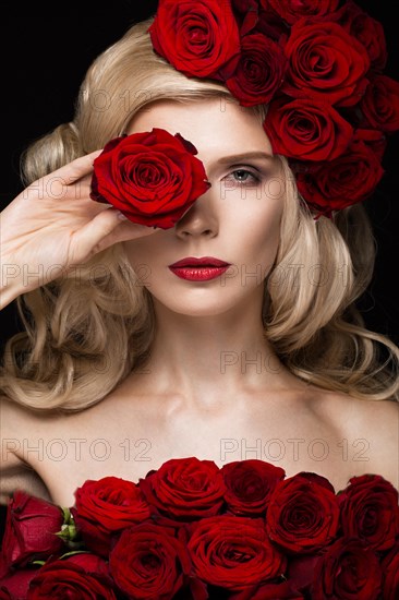 Beautiful blond girl in a dress and hat with roses