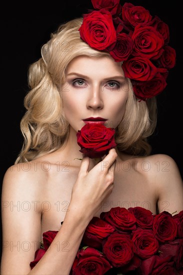 Beautiful blond girl in a dress and hat with roses