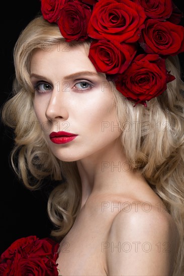 Beautiful blond girl in a dress and hat with roses