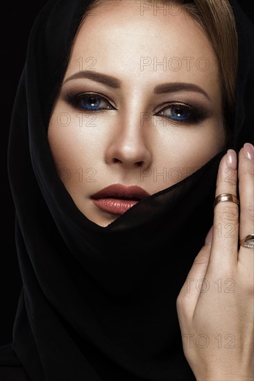 Beautiful girl in the Arab scarf with oriental make-up. Beauty face. Photos shot in the studio