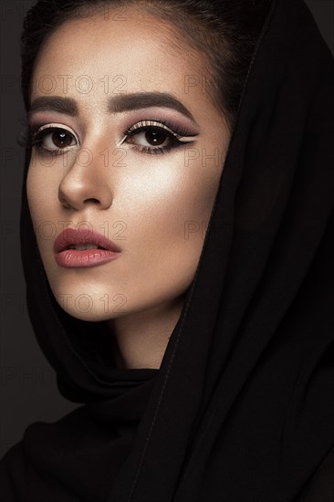 Beautiful girl in the Arab scarf with oriental make-up. Beauty face. Photos shot in the studio