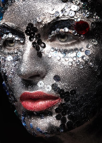 Girl with glitter and rhinestones on her face. Beauty close-up. Picture taken in the studio