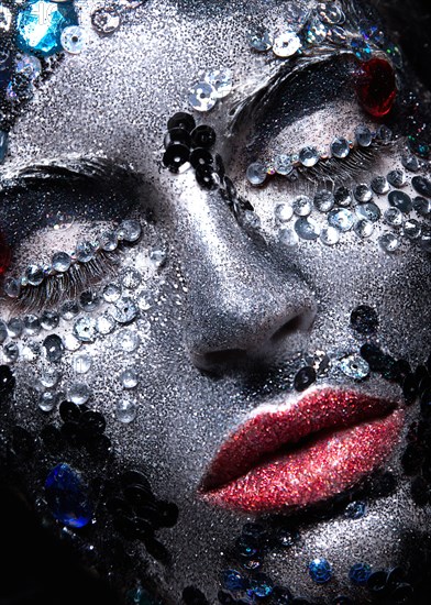 Girl with glitter and rhinestones on her face. Beauty close-up. Picture taken in the studio