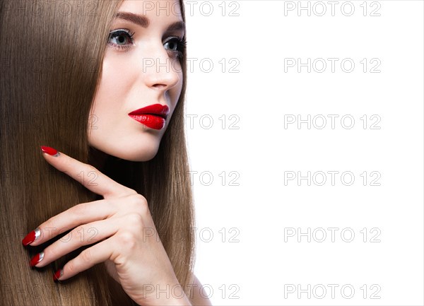 Beautiful young girl with a bright make-up and red nails. Picture taken in the studio on a white background