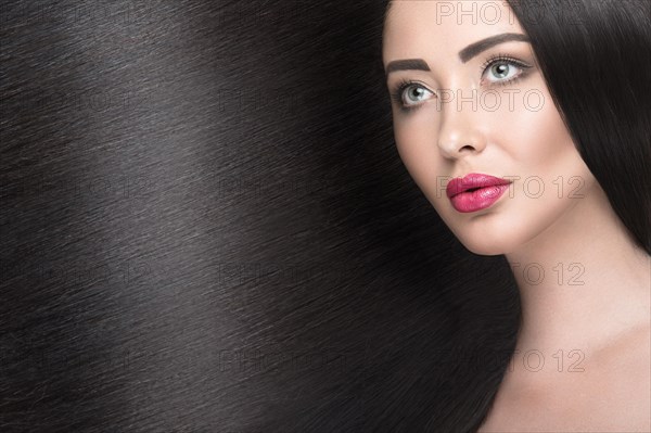 Beautiful brunette girl with a perfectly smooth hair and classic make-up. Beauty face. Picture taken in the studio on a white background