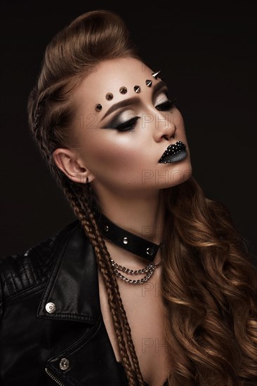 Portrait of a beautiful woman in a rock style image with creative makeup and hairstyle