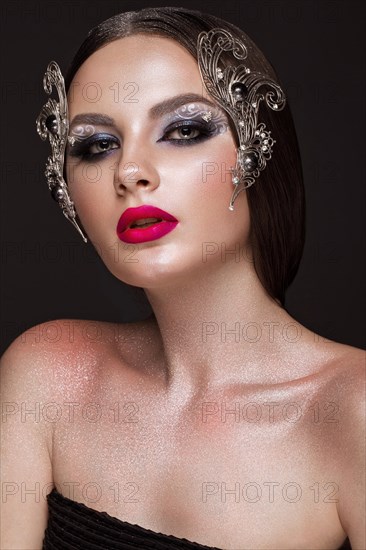 Beautiful girl with creative art make-up and silver accessories. Beauty face. Photos shot in studio