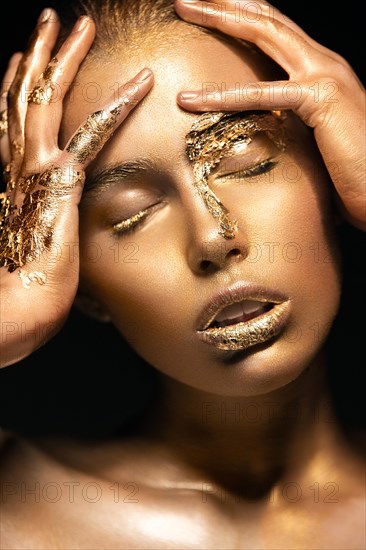 Beautyful girl with gold glitter on her face.Art image beauty face. Picture taken in the studio on a black background