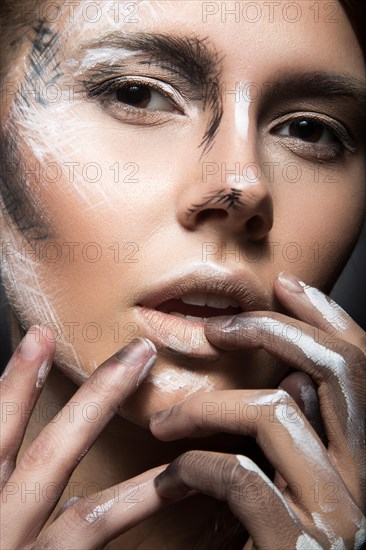 Beautiful girl with creative make-up in Gothic style and the threads of eyes. Art beauty face. Picture taken in the studio on a black background