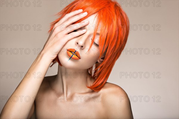 Beautiful girl in an orange wig cosplay style with bright creative lips. Art beauty image. Portrait shot in the studio