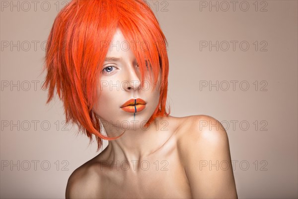 Beautiful girl in an orange wig cosplay style with bright creative lips. Art beauty image. Portrait shot in the studio