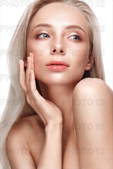 Beautiful young girl with a light natural make-up and perfect skin. Beauty face. Picture taken in the studio on a white background