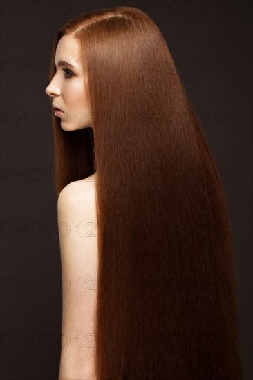 Beautiful Redheadgirl with a perfectly smooth hair and classic make-up. Beauty face. Picture taken in the studio on a white background
