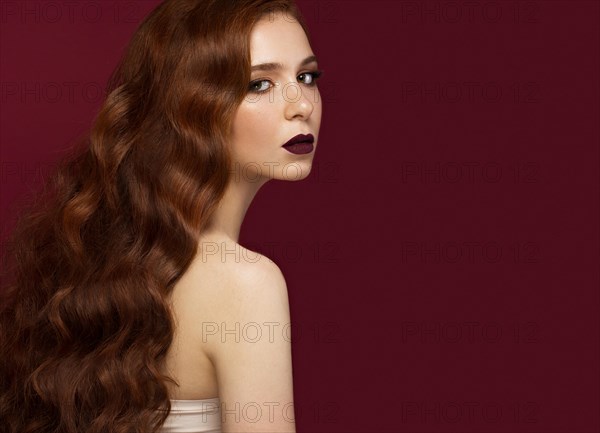 Beautiful Redhead girl with a perfectly curls hair and classic make-up. Beauty face. Picture taken in the studio