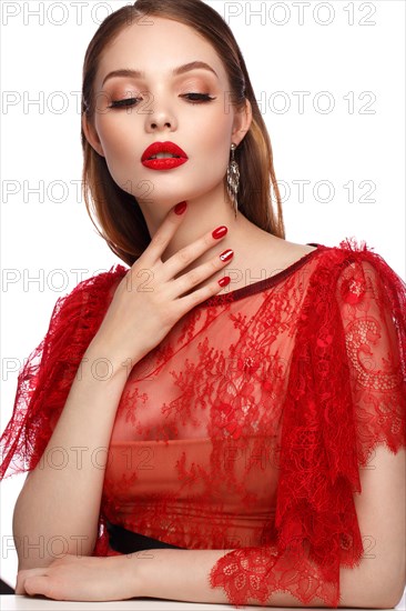 Beautiful girl in red dress with classic make-up and red manicure. Beauty face. Photo taken in the studio